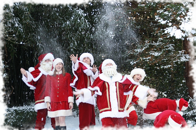 Kerstman samen met de kerstmeisjes in de sneeuw
